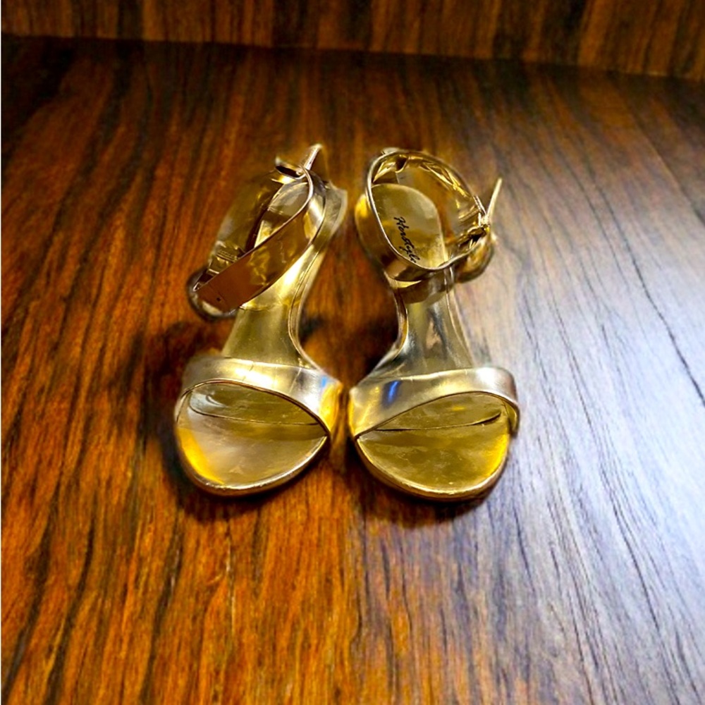 These stunning gold heels feature a sleek, metallic finish.